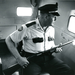 Mississippi policeman sitting in the back of a vehicle holding a rifle at the ready