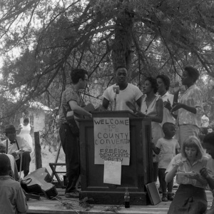 Group standing at a podium during the County Convention of the Freedom Democratic Party, Freedom Summer, Mississippi, 1964.