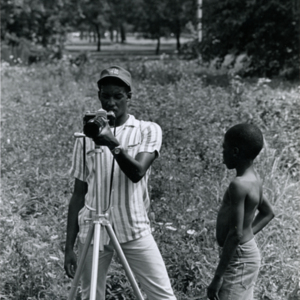 LeMoyne Coates taking photographs while Curtis Wilson watches in Forest Park, St. Louis during production of "More Than One Thing"
